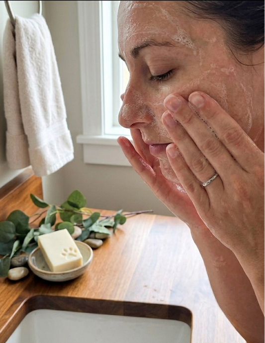 Woman washing to her face in a bathroom setting with naked soap.