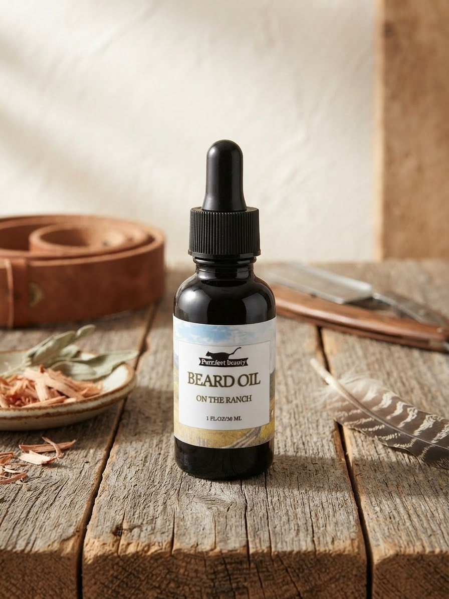 A bottle of Beard Oil by The Ranch on the Ranch, styled on a rustic wooden table with leather, dried herbs, and a feather.