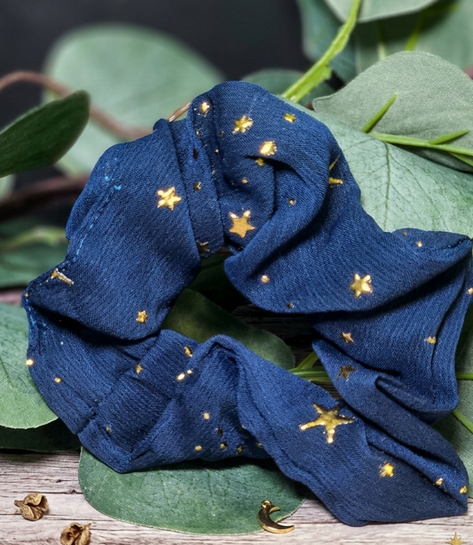 Blue scrunchie with gold star patterns on green leaves