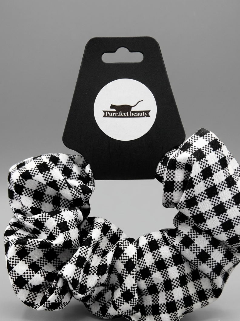 Black and white checkered scrunchie with a branded card in the background