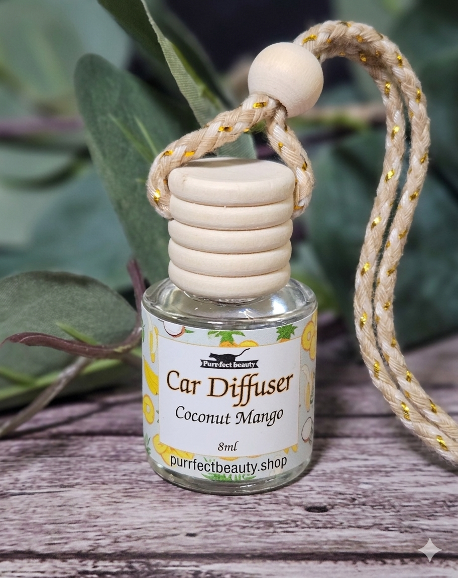 Car diffuser with coconut mango fragrance on a wooden surface with green leaves in the background