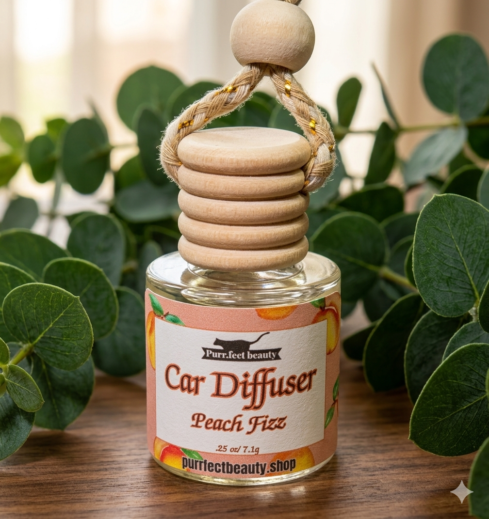 Peach Fizz Car diffuser with wooden design on a wooden surface with green leaves in the background