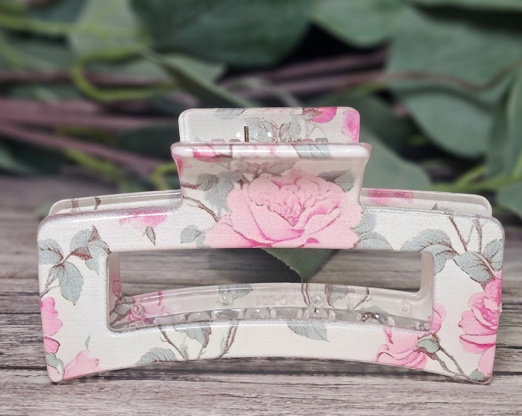 Floral-patterned tissue holder on a wooden surface with green foliage in the background
