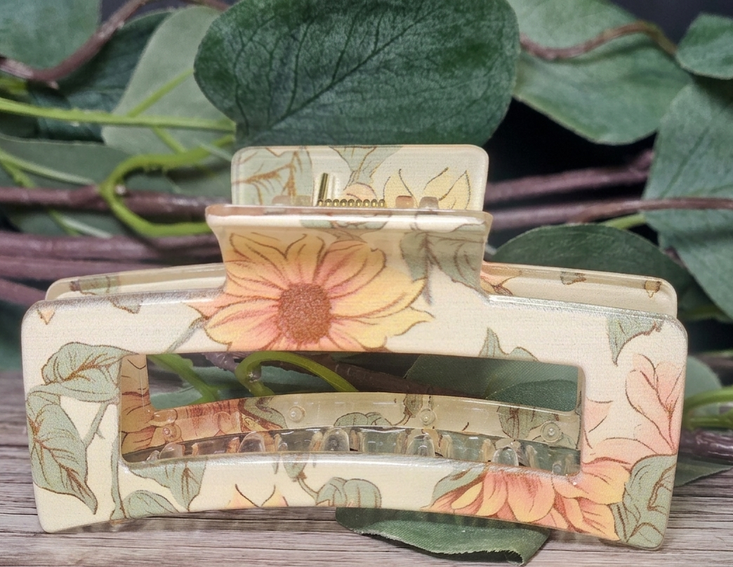 Decorative  floral design  claw clip on a wooden surface with leaves in the background