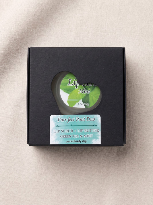 A black square gift box with a circular cutout and a front label reading 'Pure Feel Pent Duo' and 'Green Tea & Mint,' photographed on a light beige fabric background.