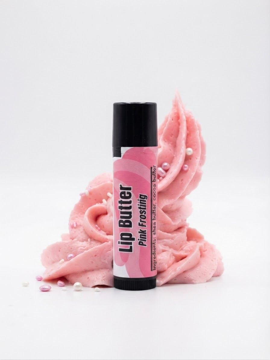 A tube of lip butter labeled 'Pink Frosting' stands upright in front of a sculpted swirl of pink frosting with small pearl-like sprinkles, on a clean white background.